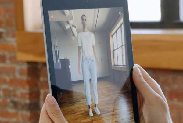 Woman holding a tablet on which she uses the virtual fitting room